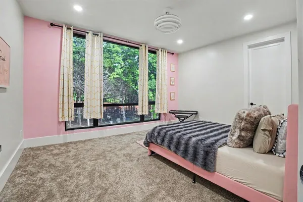 a bedroom with a bed and a large window