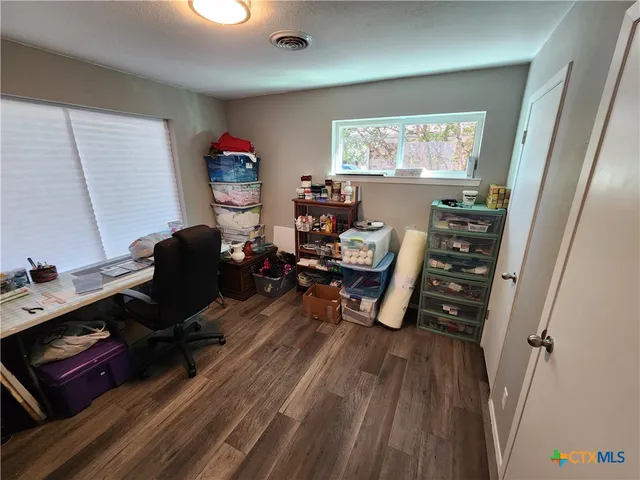 a view of a workspace with furniture and a window