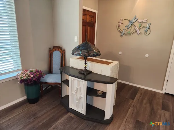 a view of a hallway with wooden floor and a potted plant