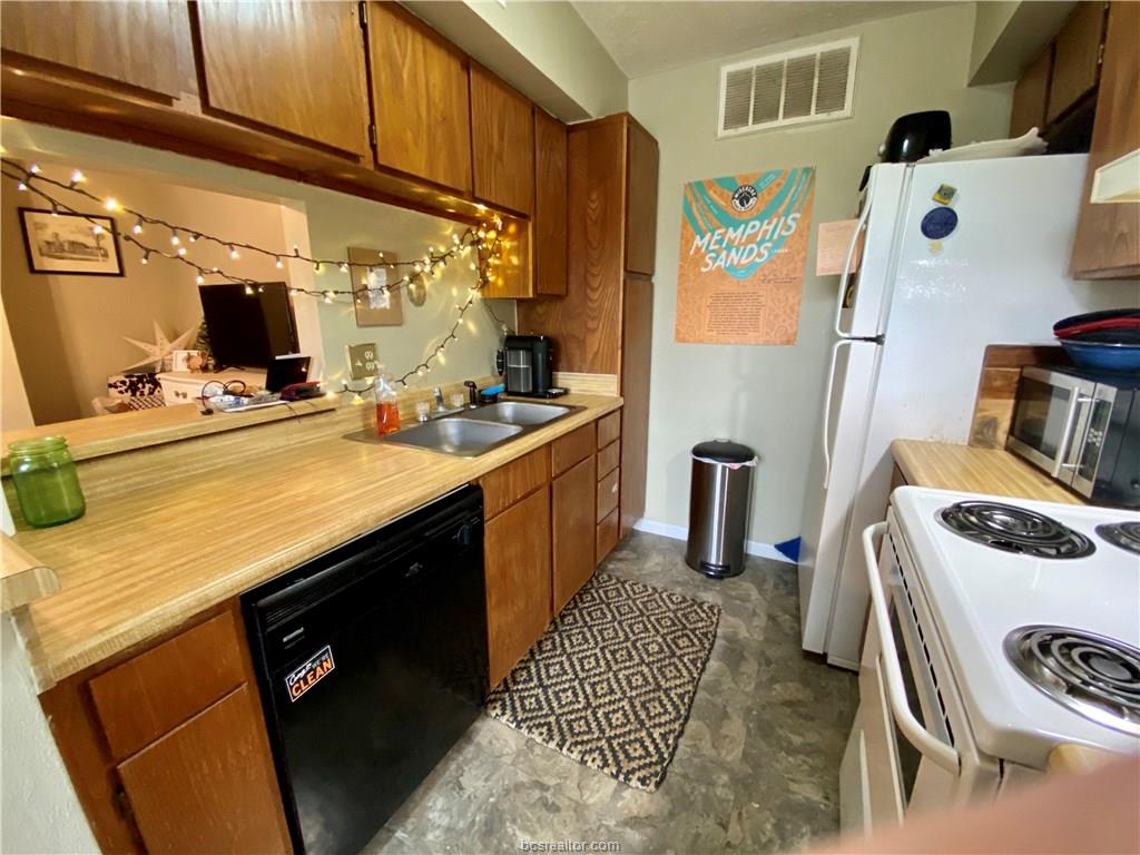 4441 Old College Road, Unit 4203 Bryan, TX 77801 - Photo 2 of 6 a kitchen with stainless steel appliances a sink and a refrigerator