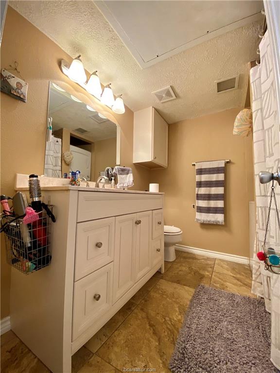 4441 Old College Road, Unit 4203 Bryan, TX 77801 - Photo 5 of 6 a bathroom with a double vanity sink mirror and toilet