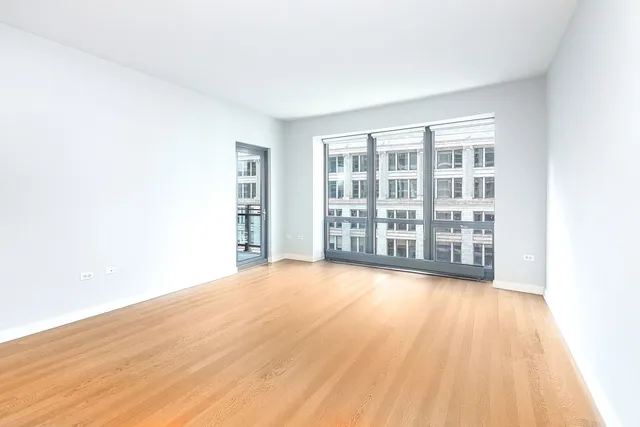 a view of a big room with wooden floor and windows