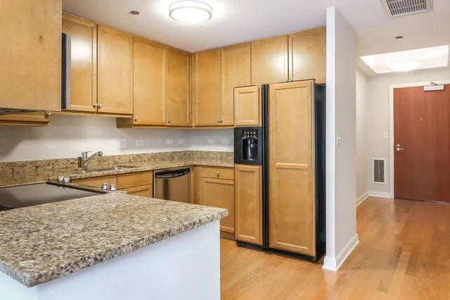 a kitchen with granite countertop cabinets stainless steel appliances and wooden cabinets