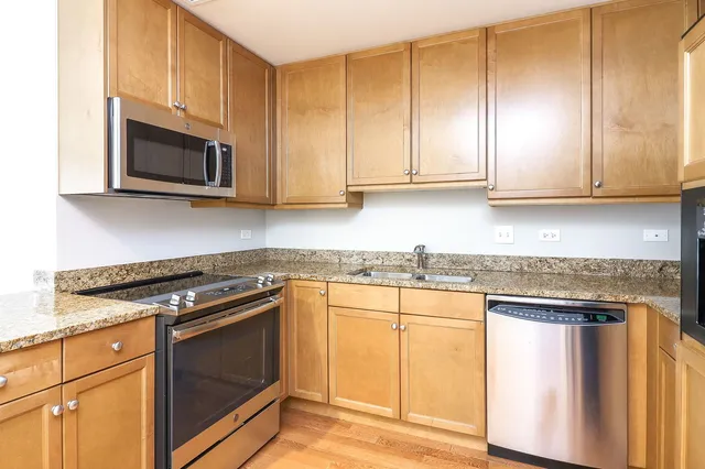 a kitchen with granite countertop a stove and a microwave