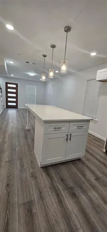 a room with wooden floor and white cabinets