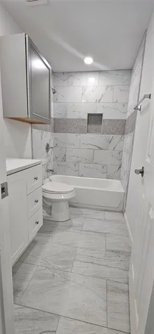 a bathroom with a bathtub sink vanity and mirror