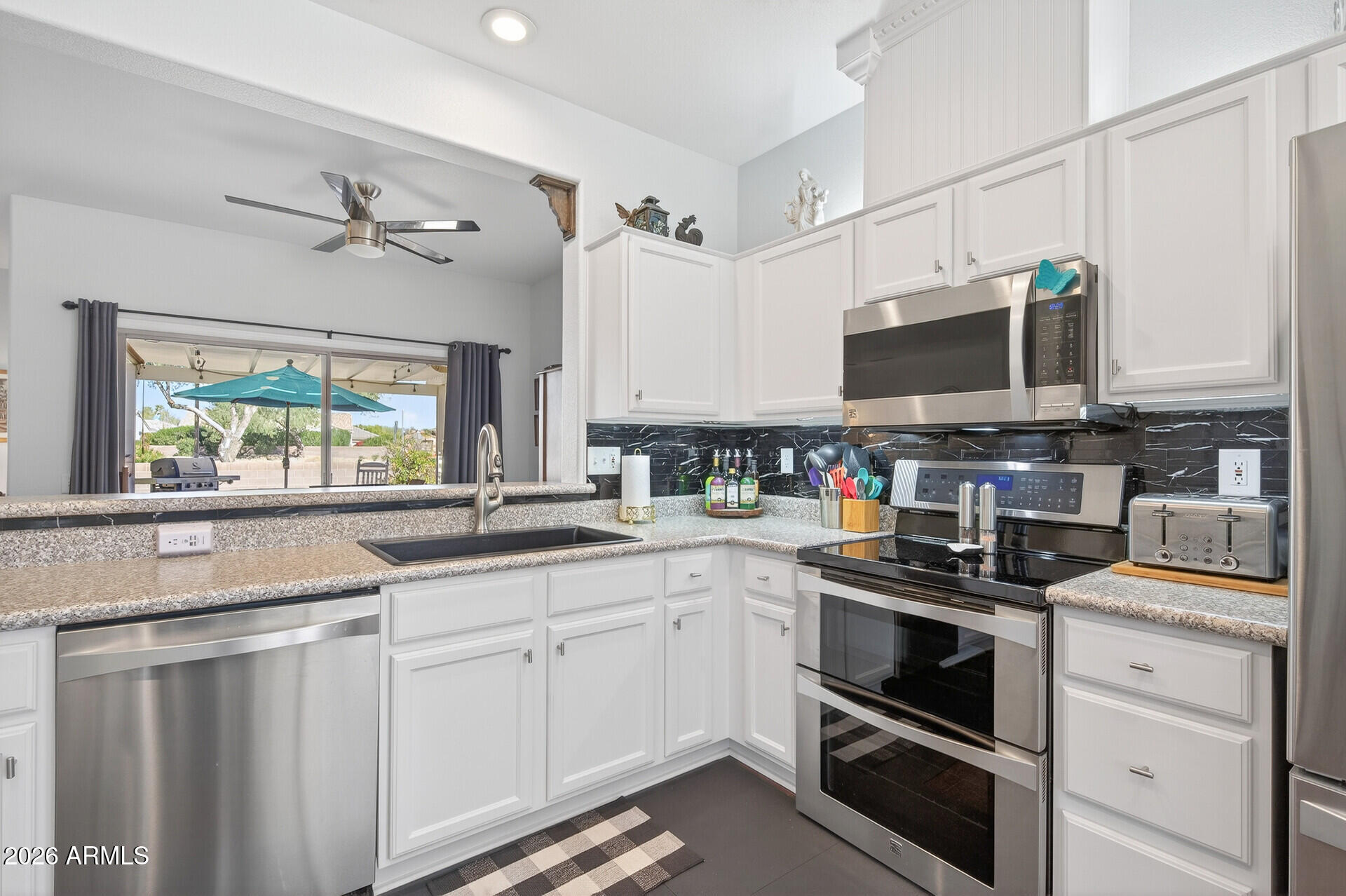 16100 West Eagle Ridge Drive Surprise, AZ 85374 - Photo 14 of 44 a kitchen with stainless steel appliances a stove microwave and sink