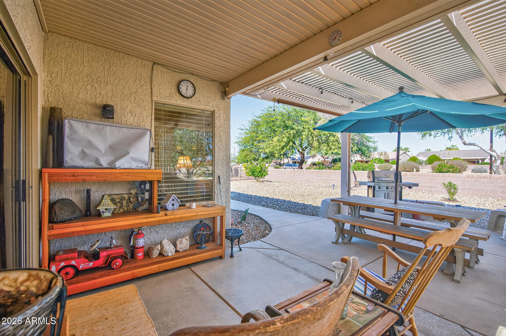 16100 West Eagle Ridge Drive Surprise, AZ 85374 - Photo 35 of 44 an outdoor sitting area with chairs and table under an umbrella