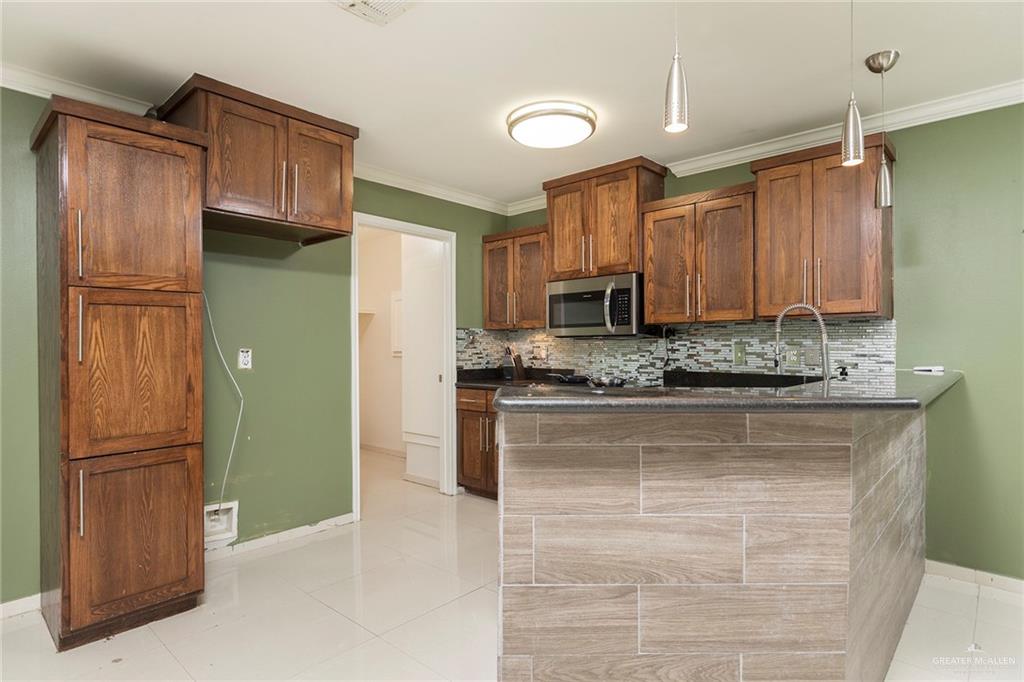 103 South 48th Lane, Unit 1 McAllen, TX 78501 - Photo 6 of 20 a kitchen with stainless steel appliances granite countertop a refrigerator and microwave