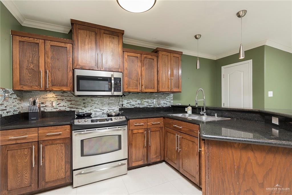 103 South 48th Lane, Unit 1 McAllen, TX 78501 - Photo 7 of 20 a kitchen with granite countertop cabinets stainless steel appliances and a sink