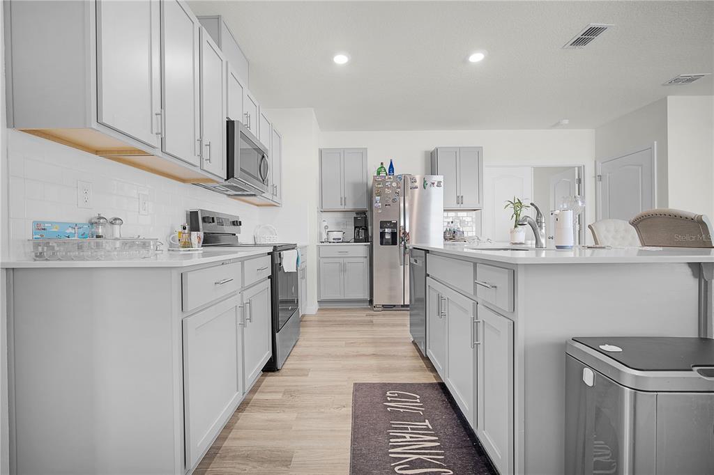 1606 Bull Hl Road Kissimmee, FL 34744 - Photo 19 of 38 a kitchen with counter top space cabinets and stainless steel appliances