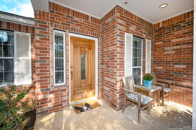 a view of a brick house with a chairs and table in a patio
