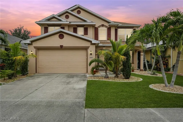 a front view of a house with a yard garage and a fountain