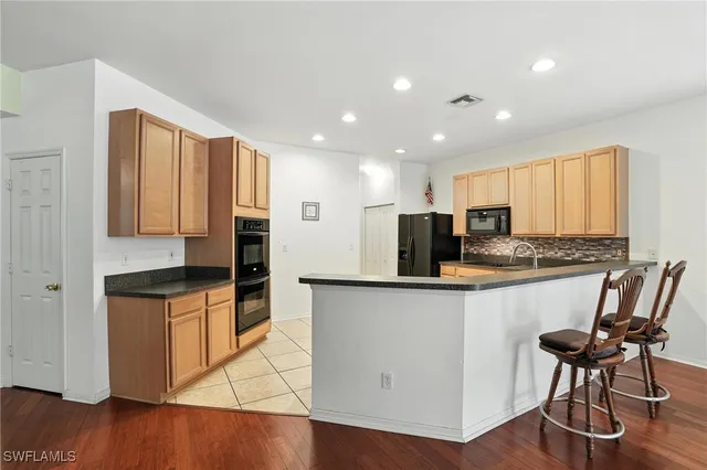 a kitchen with granite countertop white cabinets and stainless steel appliances
