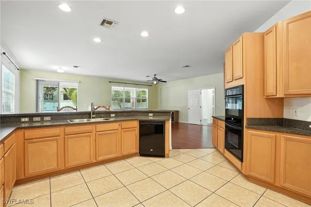 a kitchen with stainless steel appliances granite countertop a refrigerator and a stove top oven