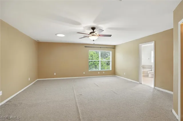 an empty room with windows and ceiling fan