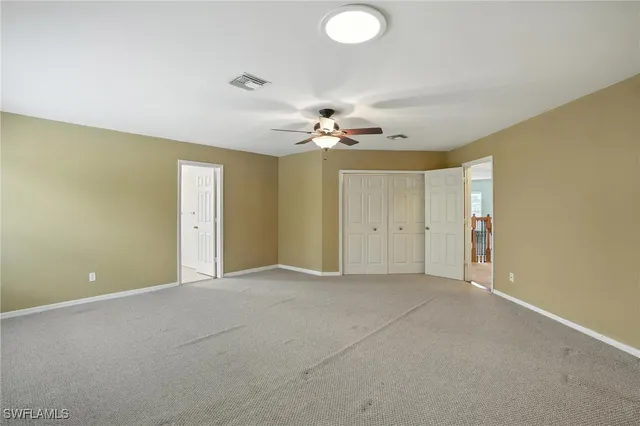 a view of an empty room with a ceiling fan