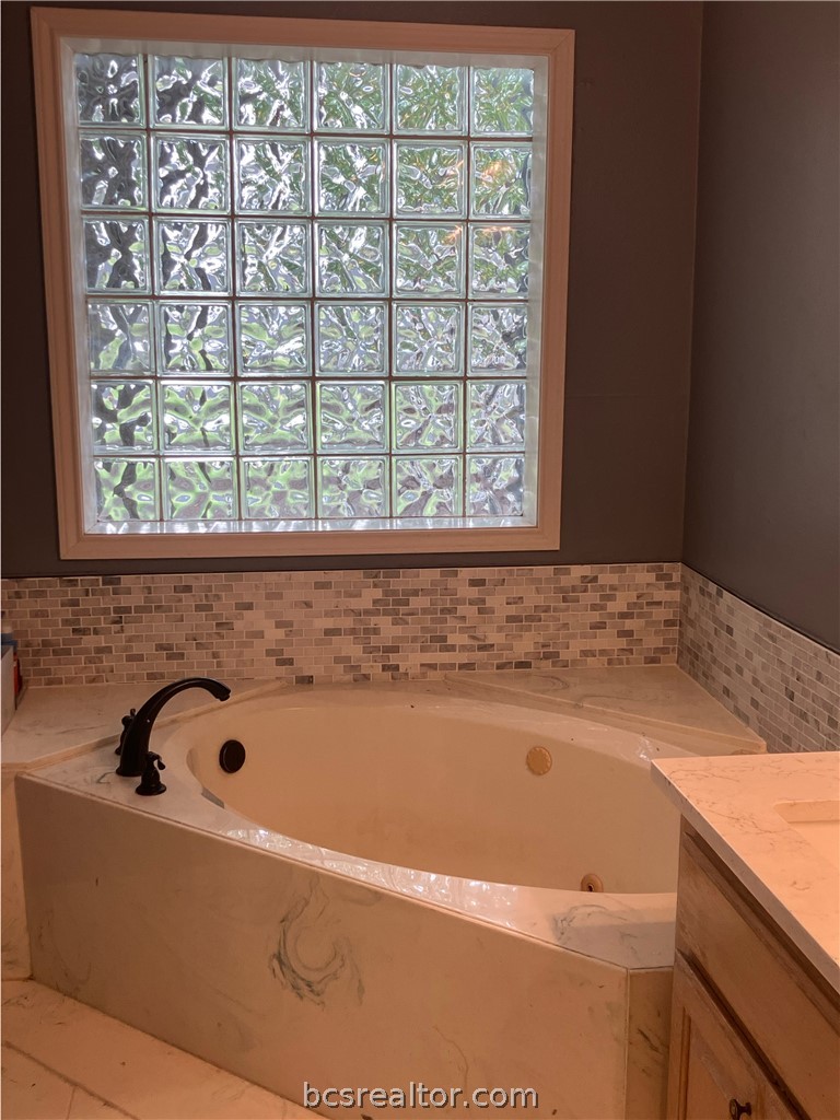 5660 Falling Water Bryan, TX 77808 - Photo 25 of 27 Bathroom with vanity and a bathtub