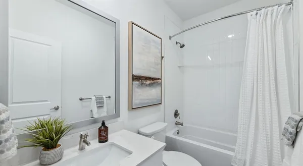 a bathroom with a shower sink vanity mirror and toilet