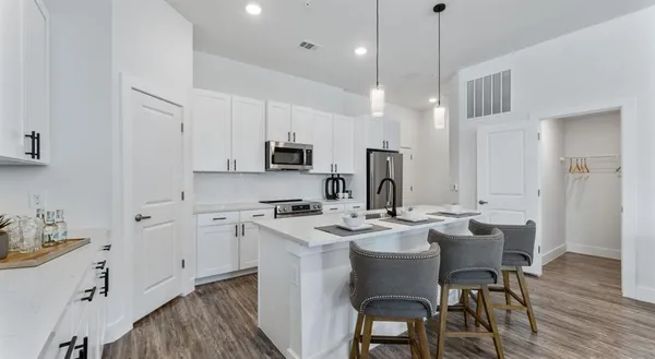 a kitchen with stainless steel appliances granite countertop a kitchen island a stove a table and chairs