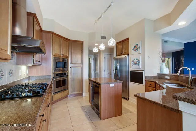 a kitchen with stainless steel appliances granite countertop a stove refrigerator and cabinets