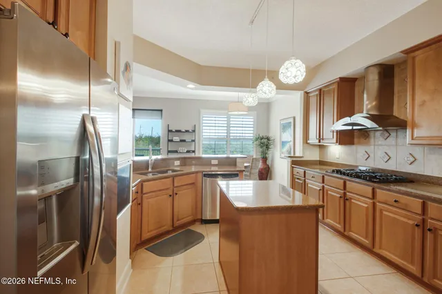a kitchen with stainless steel appliances granite countertop a sink a stove and a refrigerator
