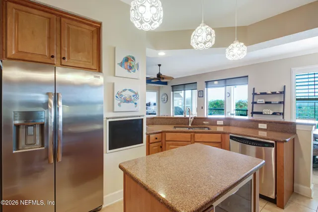 a kitchen with stainless steel appliances granite countertop a refrigerator a sink dishwasher a stove and a refrigerator with wooden floor