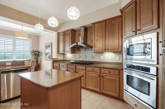 a kitchen with granite countertop a sink stainless steel appliances and cabinets