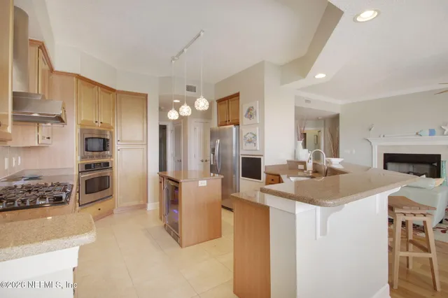 a living room with furniture a fireplace and a open kitchen view