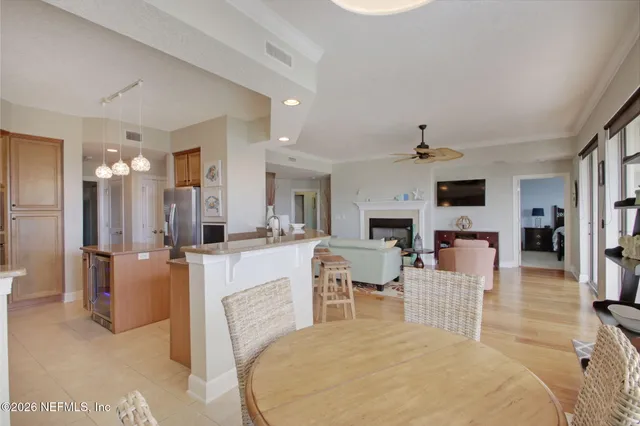 a kitchen with stainless steel appliances kitchen island granite countertop a table chairs sink and cabinets