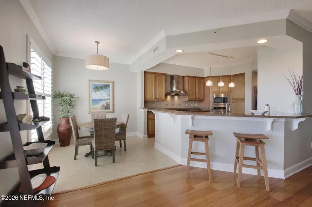 a living room with a couch a flat screen tv and kitchen view