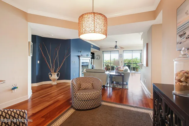 a living room with furniture a chandelier and a dining table