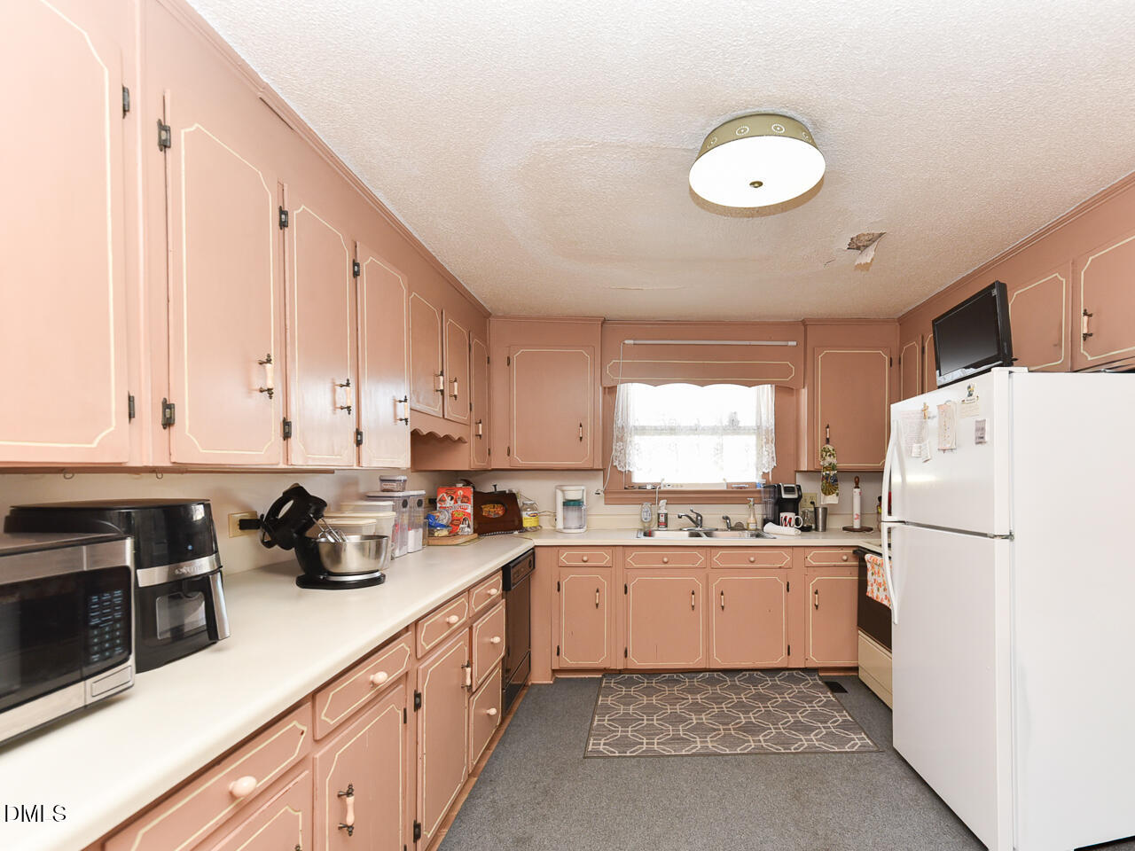 314 West Main Street Benson, NC 27504 - Photo 14 of 30 a kitchen with a sink a refrigerator and white cabinets