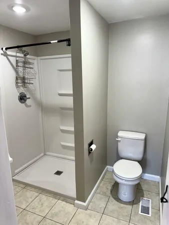 a bathroom with a toilet and a shower