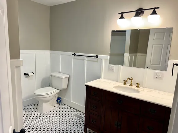 a bathroom with a sink toilet vanity and shower