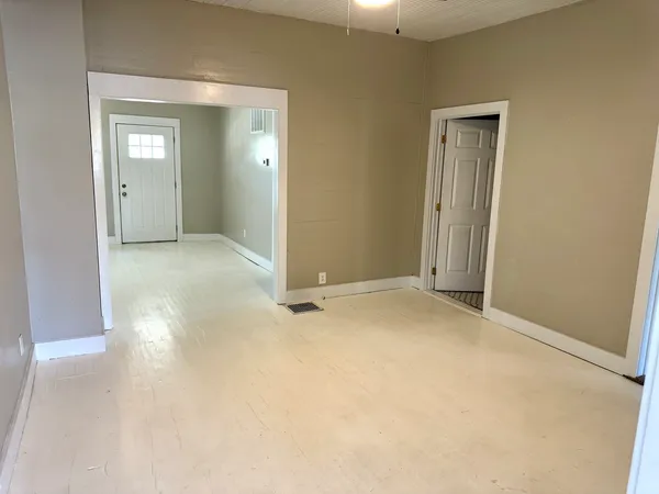 an empty room with closet and a bathroom