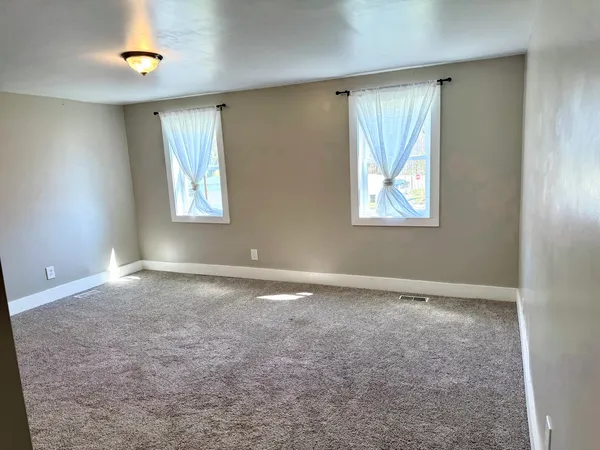 an empty room with windows and closet