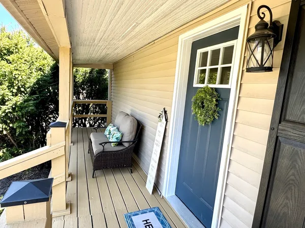 a view of a balcony with chairs and wooden floor