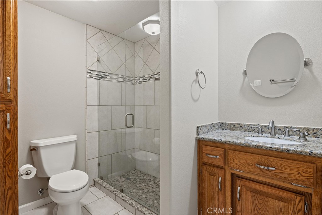 6310 County Road 18 Orland, CA 95963 - Photo 30 of 72 a bathroom with a granite countertop sink a toilet and a mirror