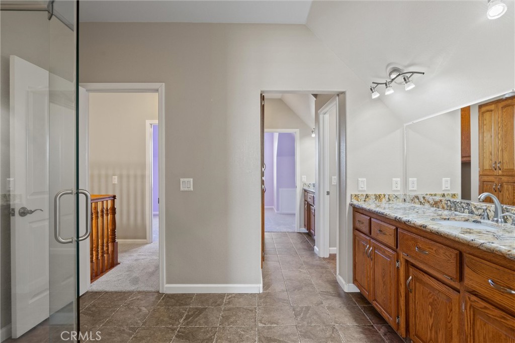 6310 County Road 18 Orland, CA 95963 - Photo 37 of 72 a bathroom with a granite countertop sink a mirror and a shower