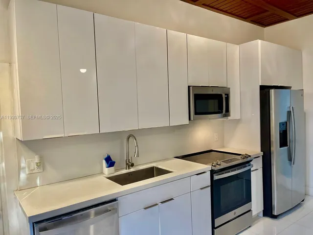 a kitchen with a sink cabinets and stainless steel appliances