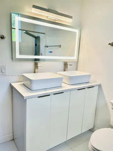 a bathroom with a sink a toilet and a mirror