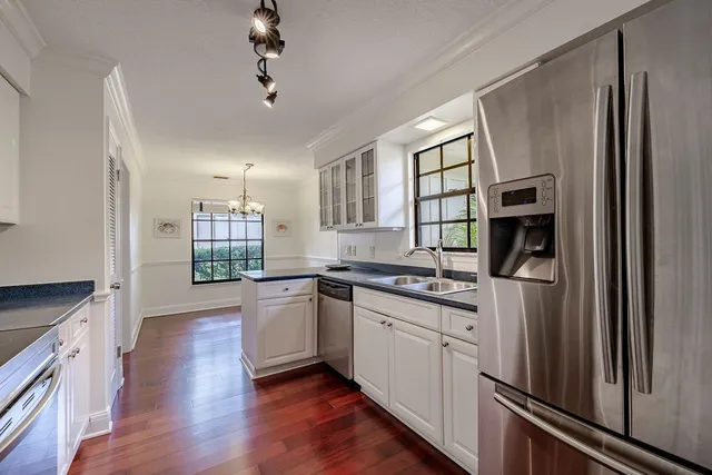 a kitchen with granite countertop a refrigerator stove and sink