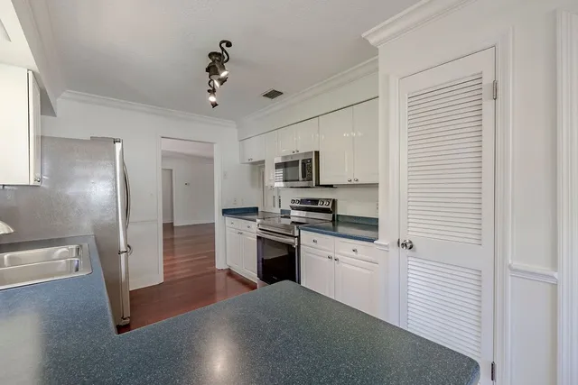 a kitchen with stainless steel appliances granite countertop a refrigerator a stove and a sink