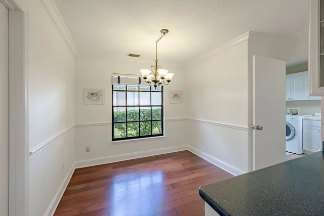 an empty room with wooden floor cabinet and windows