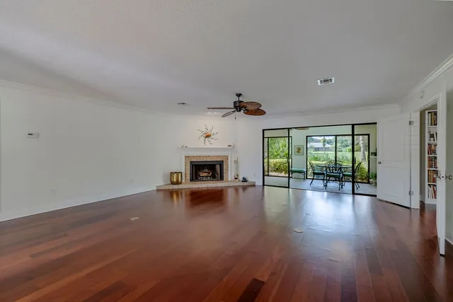 a view of empty room with fireplace and wooden floor