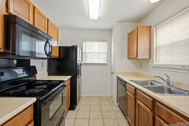 a kitchen with granite countertop a sink stove and refrigerator