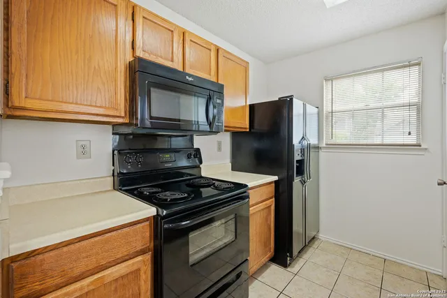 a kitchen with stainless steel appliances granite countertop a stove microwave and refrigerator