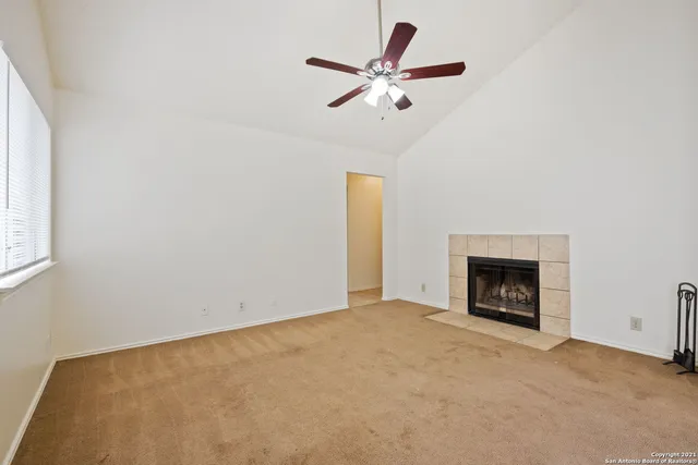 an empty room with fireplace and fan
