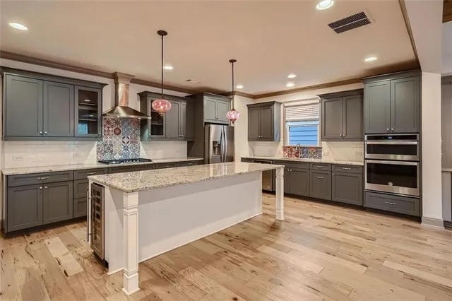 a kitchen with stainless steel appliances kitchen island granite countertop a sink and cabinets